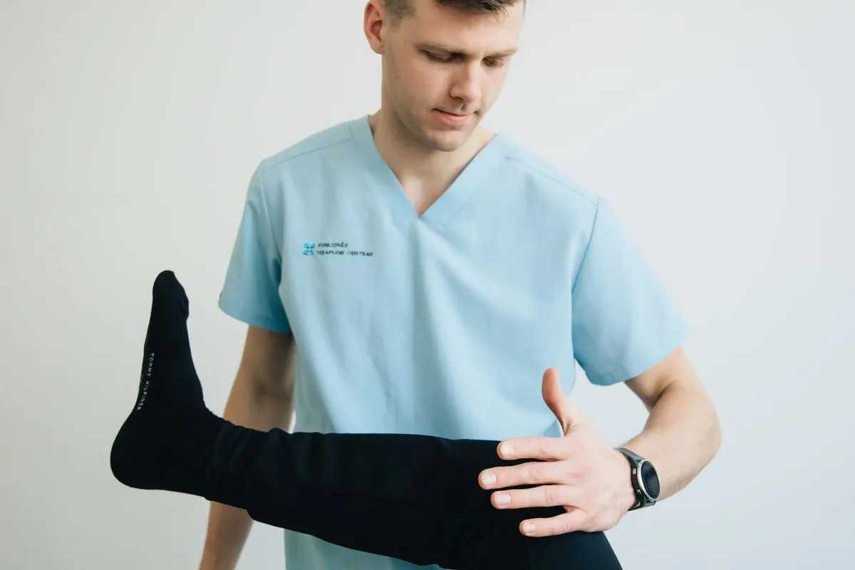 Fisioterapeuta trabajando la rodilla de un paciente en rehabilitación