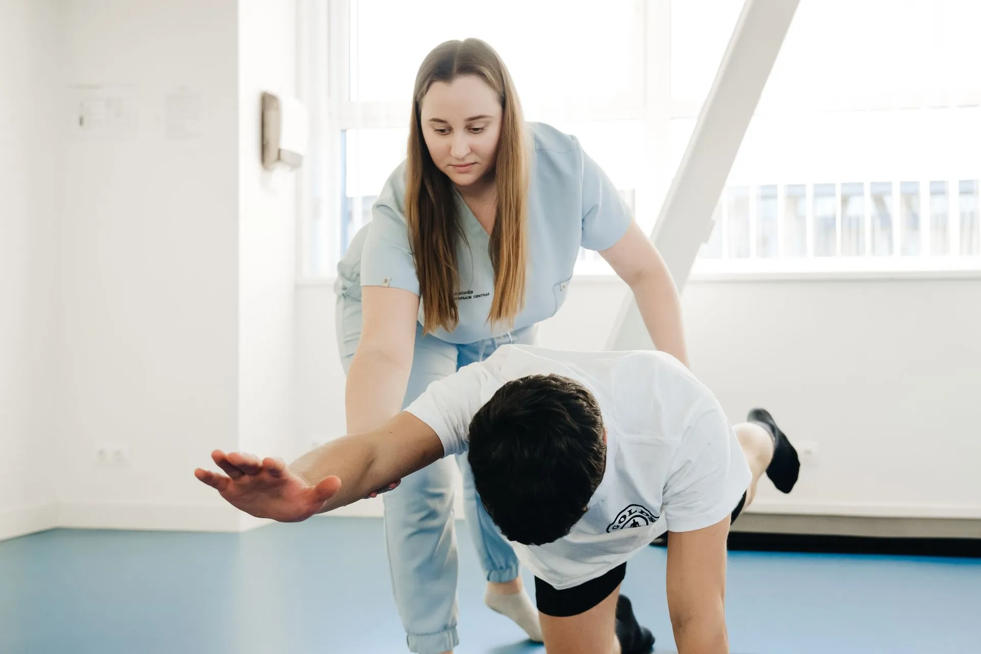 Fisioterapeuta guiando un estiramiento a un paciente durante una sesión de fisioterapia